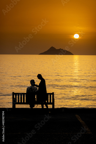 Couple relaxing on bench by sea during sunset © bruno135_406