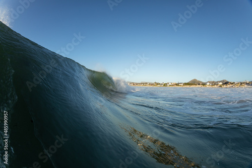 huge wave crashing on an empty beach in Kommetjie  cape town