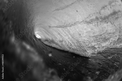 moody black and white photo of a crashing wave