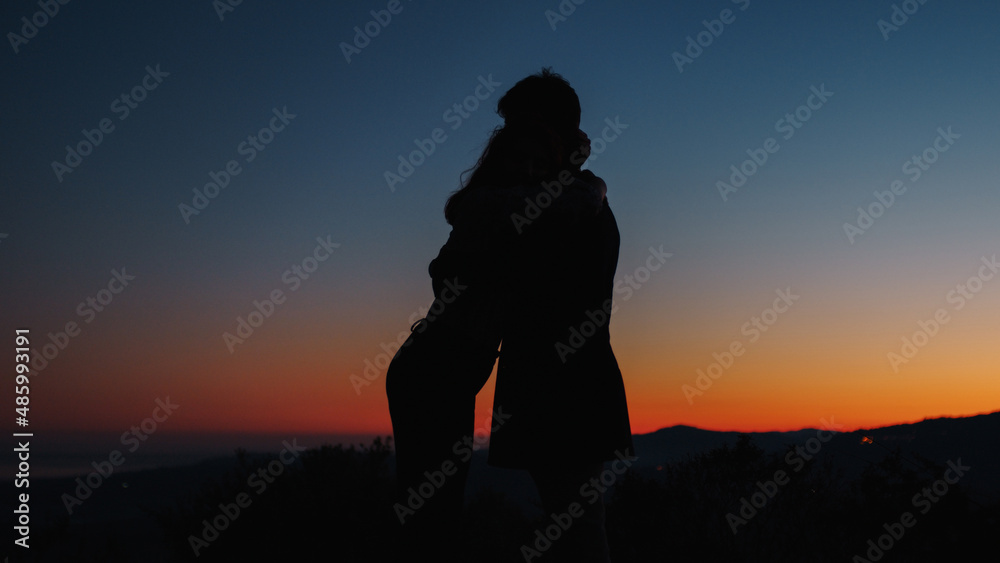 Silhouette of boy and girl hug each other 