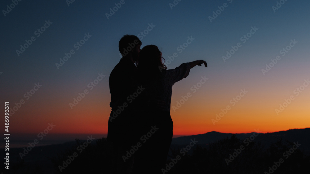 Silhouette of boy and girl look at the stars in love