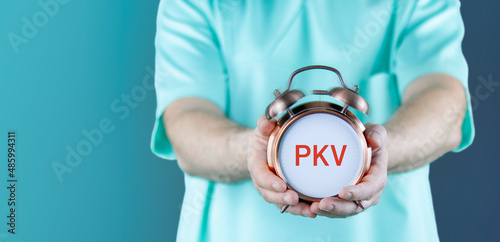 PKV (Private Krankenversicherung). Doktor zeigt Uhr/Wecker mit Text. Hintergrund blau photo