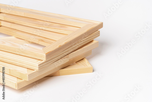 A stack of wooden stretchers on a white background  copy space