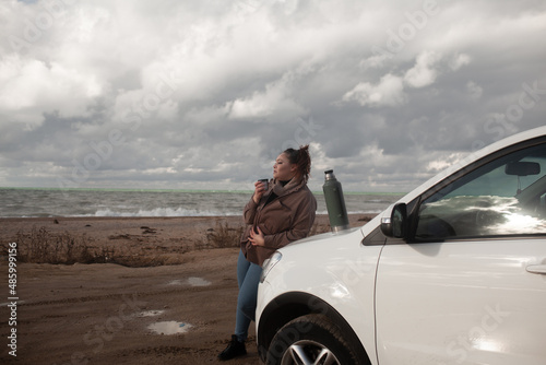 Beatuful woman with over weght body walking in the beach, The plus size model wearing jeans, the warm knitted blanket and sweater. the wind in the bich have fun with hairs. trip in the car