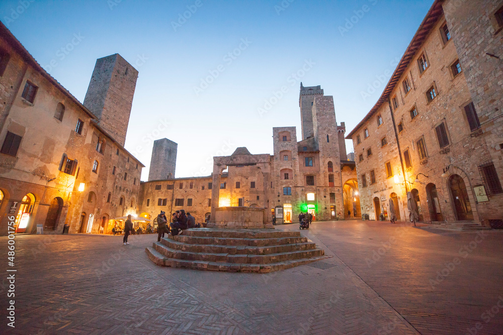 Italia, Toscana, Siena, il paese di San Gimignano con luci della sera. Piazza della Cisterna.