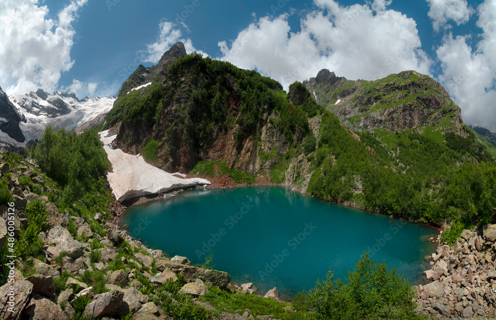 Mountain Lake Turye surrounded by green plants in the Dombai Mountains.