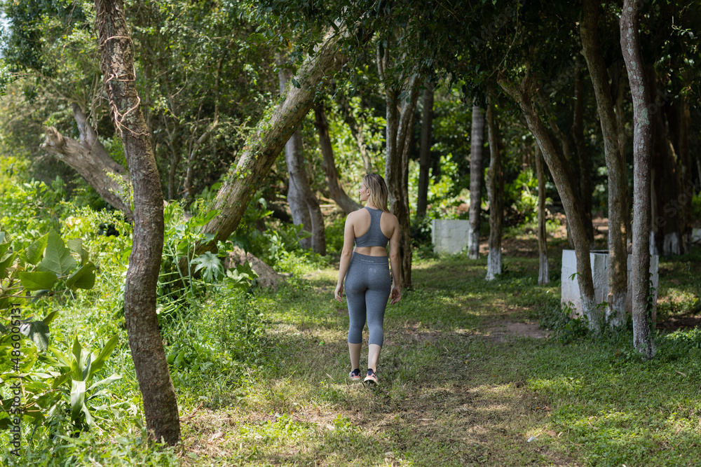 Happy oung woman exercising at a park on a beautiful sunny day. Woman working out. Green and nature background. Happy oung woman exercising at a park on a beautiful sunny day. Woman working out. Green and nature background.