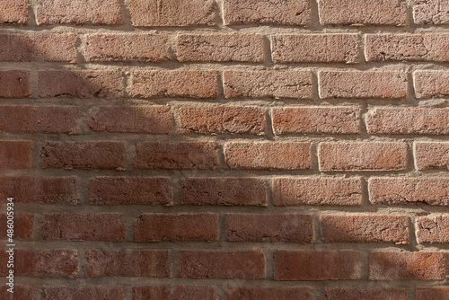 Diagonal sun shadow on old brick wall texture