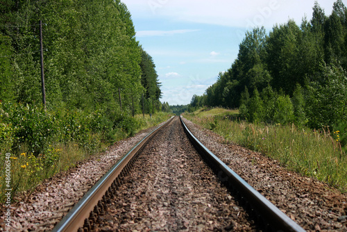 The railway track goes into the distance on a sunny summer day.