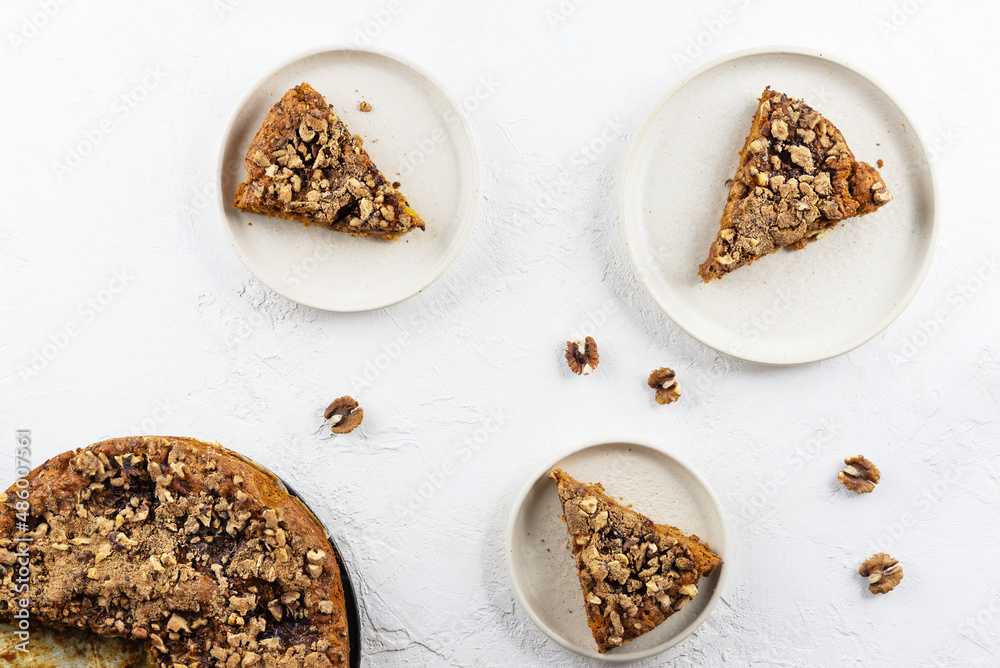 Pieces of homemade cake with walnuts on plates. Horizontal orientation, top view. Pieces of homemade cake with walnuts on plates. Horizontal orientation, top view.