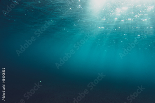 Clear blue water in ocean with sunbeams