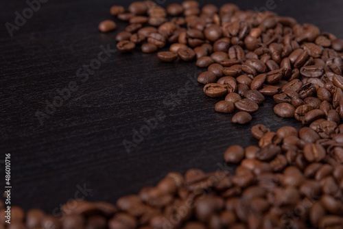 roasted coffee beans on black wood background