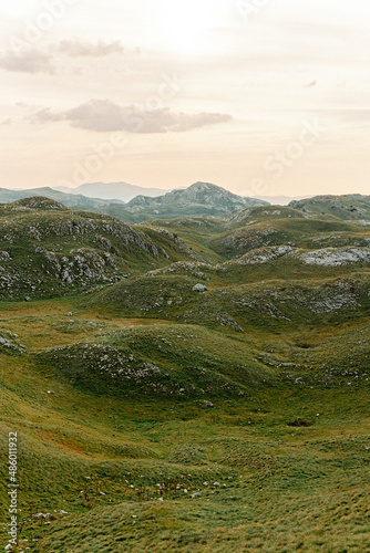 Fototapeta Naklejka Na Ścianę i Meble -  Green hills covered with stones against the sky