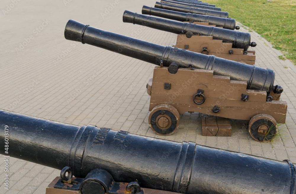 Black iron replica cannons from battleship Goto Predestination on Admiralteyskaya Square in Voronezh. Guns on gun carriage close-up. Black iron replica cannons from battleship Goto Predestination on Admiralteyskaya Square in Voronezh. Guns on gun carriage close-up.