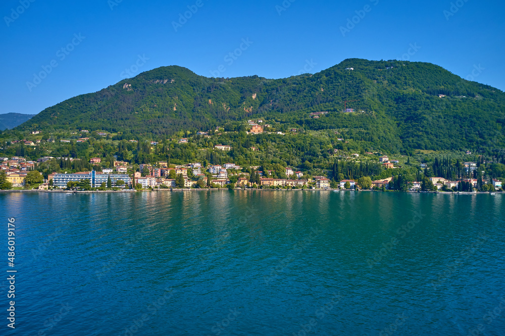 Tourist site on Lake Garda. Lake in the mountains of Italy. Aerial view of the town on Lake Garda. Panoramic view of the historic part of Salò on Lake Garda Italy.