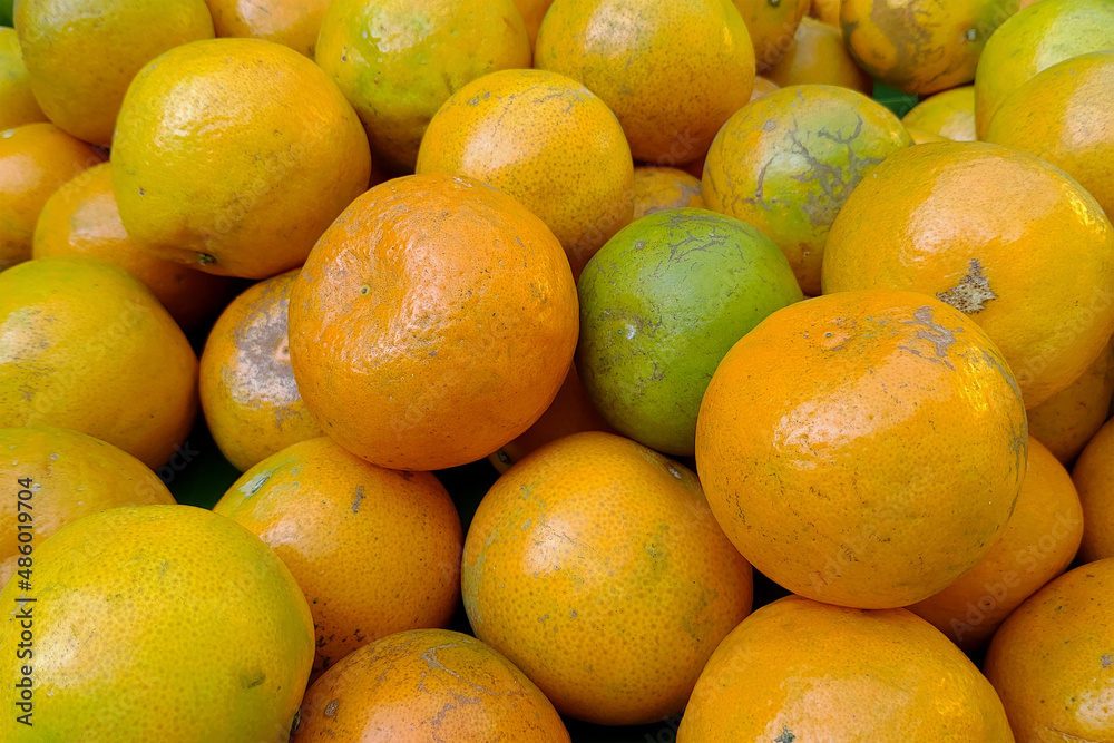 Tangerines from Thailand put together in heaps.
