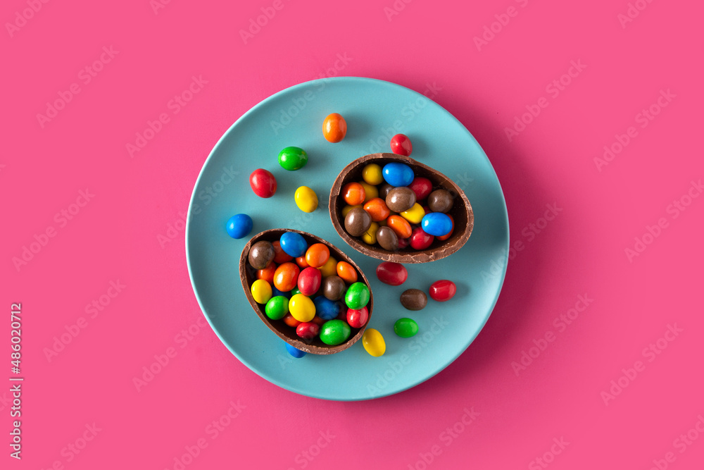 Colorful chocolate Easter eggs on pink background