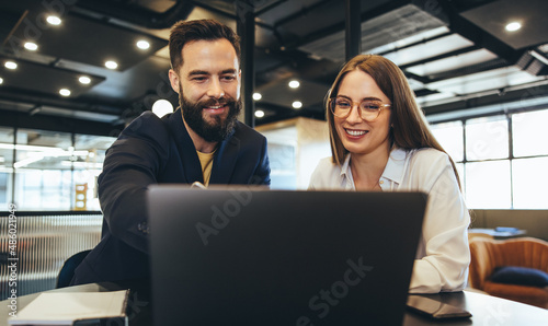 Businessman showing his colleague something on a laptop