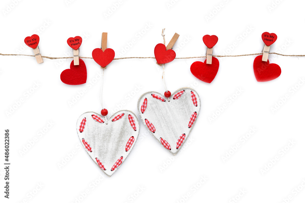 Fototapeta premium Clothespins with red hearts on rope isolated on white background. Top view. Greeting card.