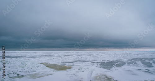 Frozen Baltic sea during cloudy winter day in Latvia.