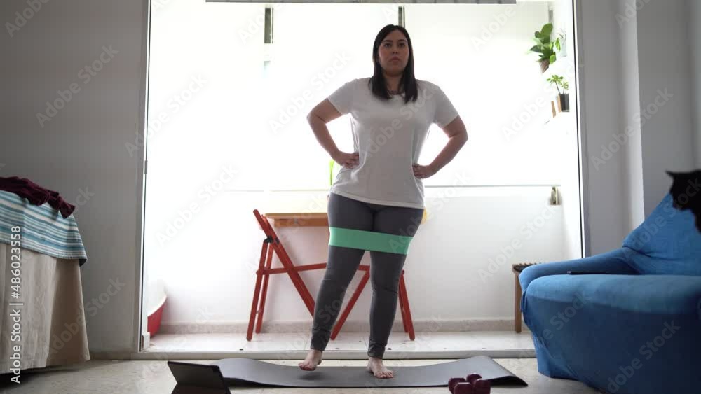 Chica joven guapa haciendo ejercicio en el salón de su casa