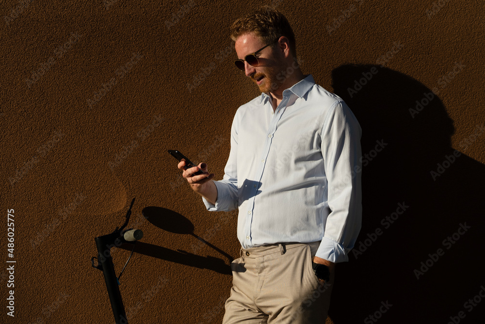 Young happy businessman outdoors. Portrait of handsome man using the phone. Young happy businessman outdoors. Portrait of handsome man using the phone.