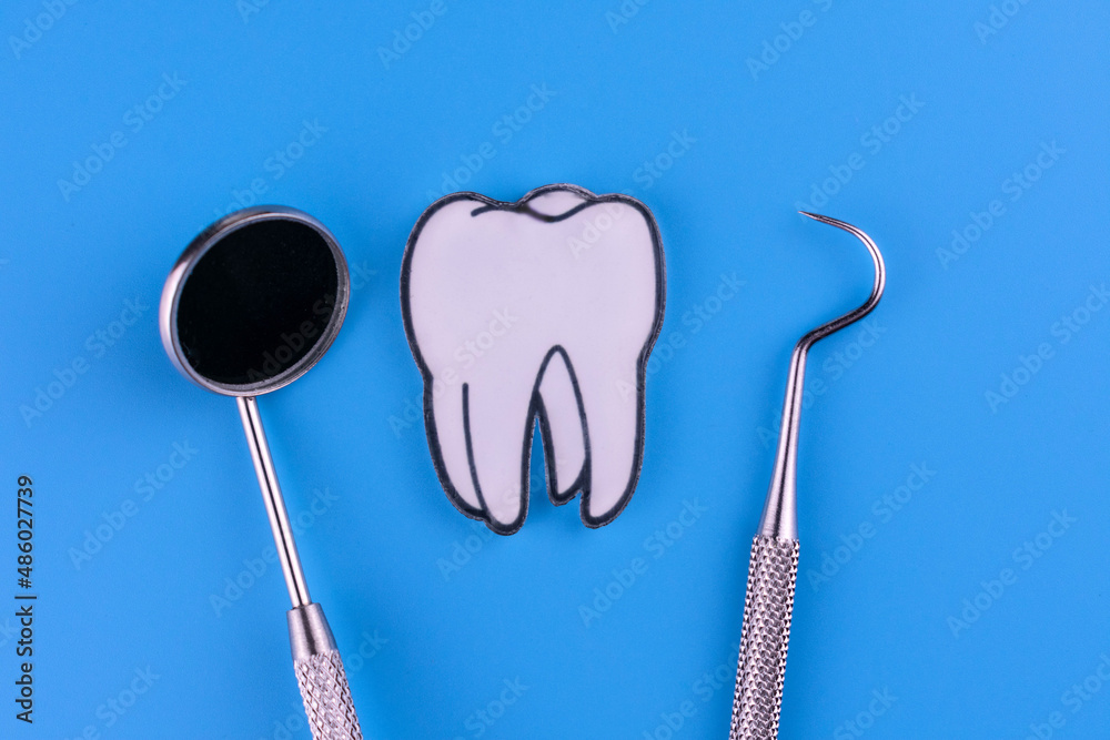 Tooth and dentist tool on a blue background. Tooth and dentist tool on a blue background.