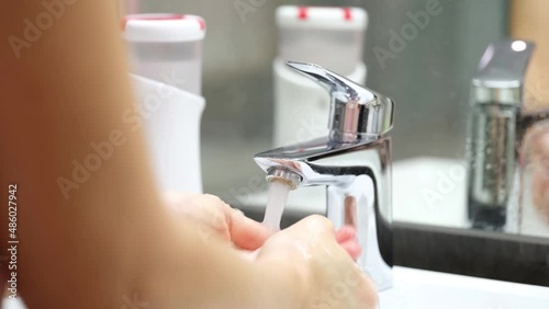 Wallpaper Mural Person washes hands from automatic soap dispenser in bathroom closeup Torontodigital.ca