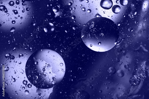 Close up of drops and bubbles in water toned in very peri