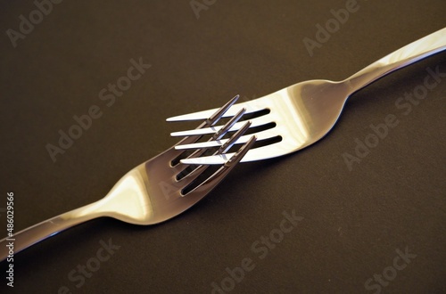 two interlocking silver forks in authentic gray colors