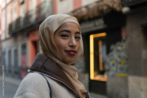 Gorgeous muslim woman with toothy smile and scarf on head posing outdoors