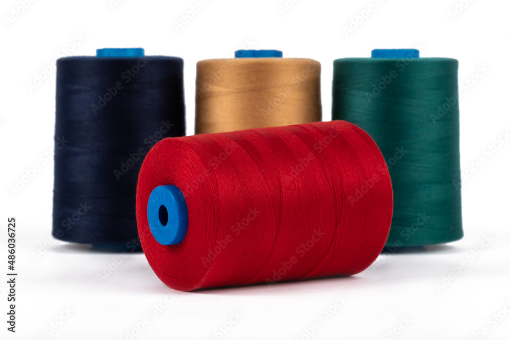 Spool of sewing thread, isolated on white background. Colored yarns used by factories in the clothing industry. Threads wound on the spool. Colored reels Spool of sewing thread, isolated on white background. Colored yarns used by factories in the clothing industry. Threads wound on the spool. Colored reels