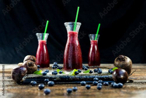 Juice with Beetroot, blueberries and mint in glass jar with fruits and vegetables on the wooden table. Detox, diet, healthy, vegetarian drink concept