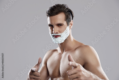 Confident caucasian man with shaving foam on face photo