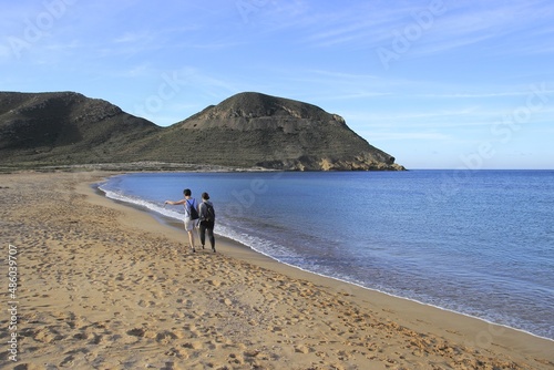 two women friends on vacation walking along the beach of Rodalquilar, Cabo de Gata, Almería, Spain, Photo with space for advertising, blank space for your promotional text or advertising content,