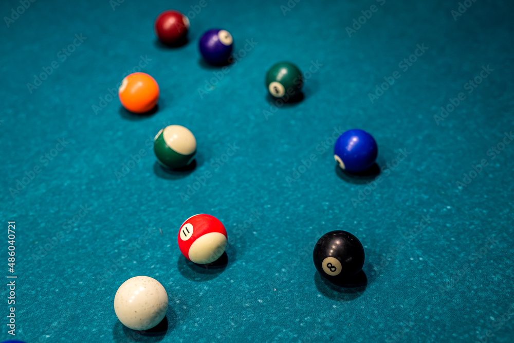 beautiful multi-colored balls with numbers lie under the light of lamps on the pool table. beautiful multi-colored balls with numbers lie under the light of lamps on the pool table.