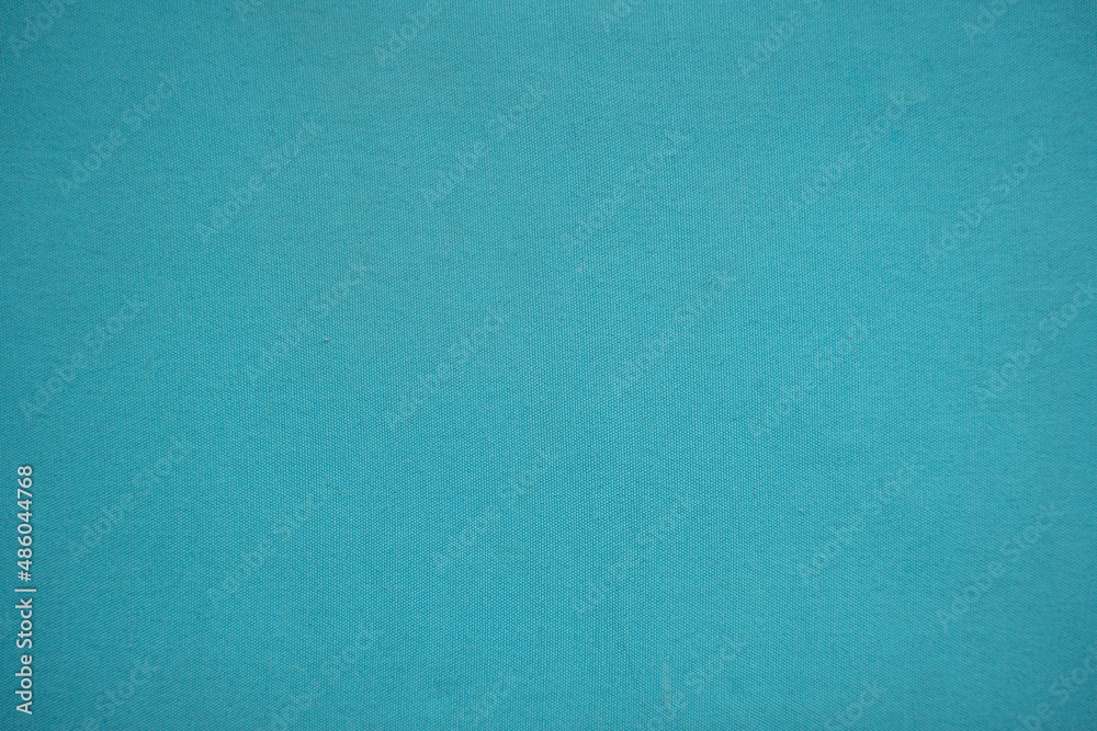 a bright turquoise blue textured woven fabric background a bright turquoise blue textured woven fabric background