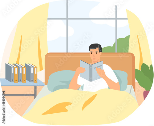 Cute man in pajamas reading literature on his bed comfortably. Book lover concept with young man lying relax on sofa and reading book. Concept of homeward and comfort. Person relaxes after work