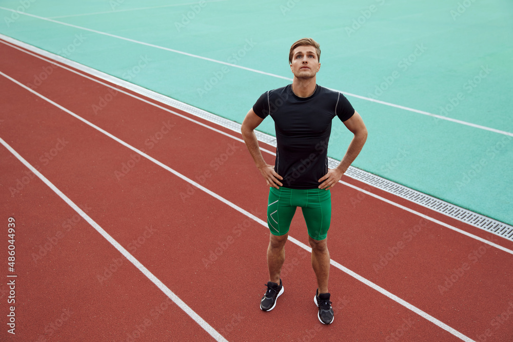 Sports man stretching before run on treadmill