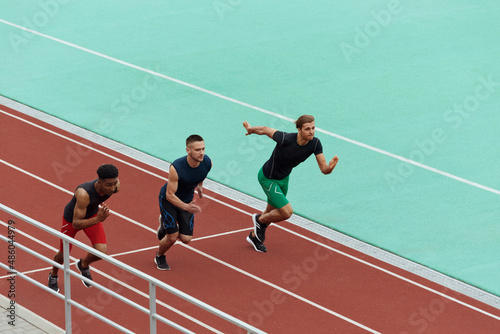 Sports men running on treadmill on stadium © Drobot Dean