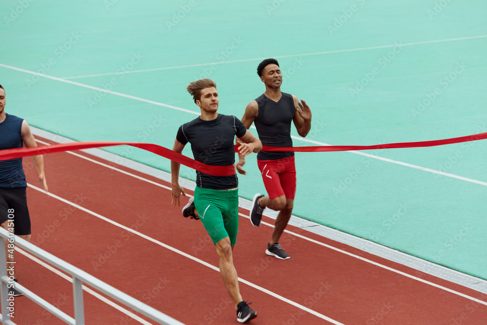 Obraz premium Sportsmen run on finish on treadmill on stadium