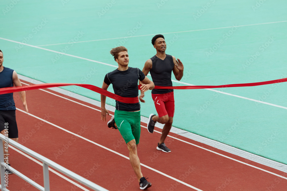 Sportsmen run on finish on treadmill on stadium