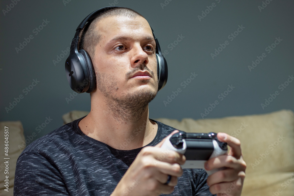 Man playing video games with headphone - front view Man playing video games with headphone - front view