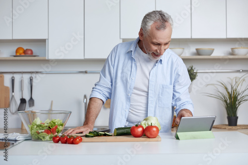 Man watch on digital tablet while cook at kitchen