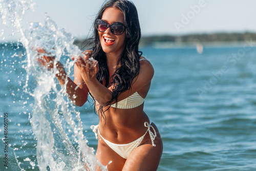 Canvas Print people, summer and leisure concept - happy laughing young woman in bikini swimsu