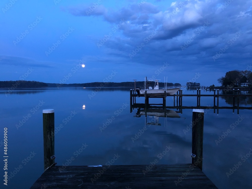 Fototapeta premium Waterfront landscapes in Piney Point, Maryland with beautiful sunrises, sunsets, and a golden doodle.