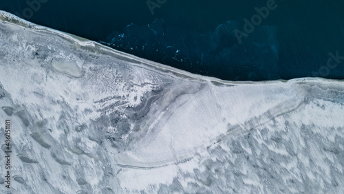 Top view of conspiracy pattern edge of frozen ice lake. theme of global warming, melting glaciers photo