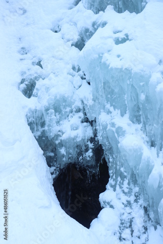 frozen waterfall of a mountain river in pits blue frozen ice cube 20 meters high