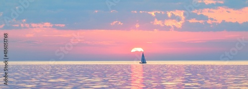 Tableau sur toile Sloop rigged yacht sailing in an open Baltic sea at sunset