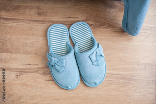 Slippers of female home turquoise color stand on the floor (top view)